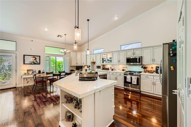 521 Dawn Cove Dr, Henderson, NV 89052 - kitchen with stainless steel appliances, a high ceiling, an island with sink, a sink, and dark wood-style floors