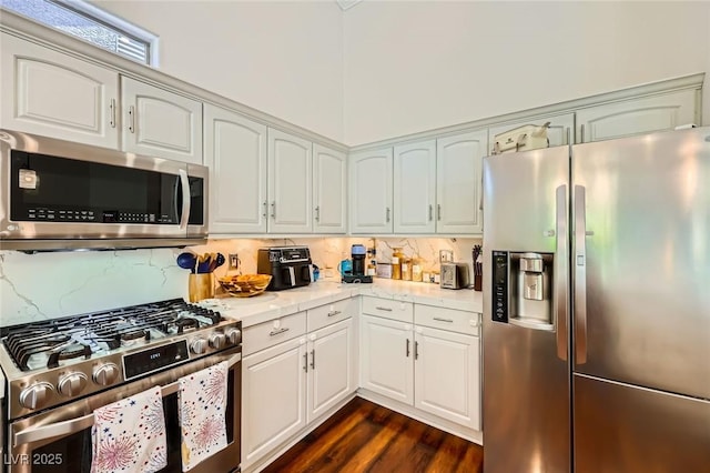 521 Dawn Cove Dr, Henderson, NV 89052 - kitchen featuring appliances with stainless steel finishes, decorative backsplash, dark wood-style floors, and white cabinetry