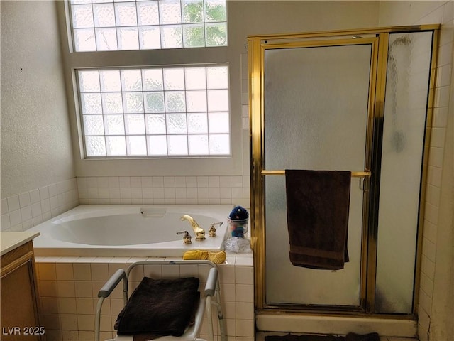 bathroom with plenty of natural light, a shower stall, and a bath