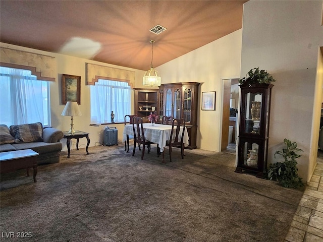 living room with a notable chandelier, visible vents, dark carpet, and lofted ceiling