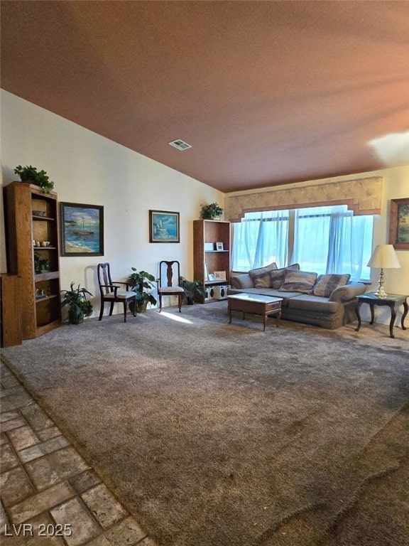carpeted living room featuring visible vents, a textured ceiling, and lofted ceiling