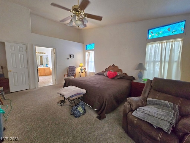 carpeted bedroom featuring connected bathroom, ceiling fan, multiple windows, and lofted ceiling