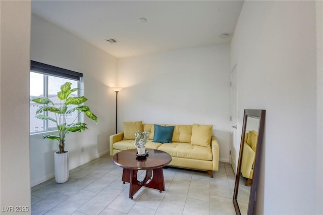 living room with light tile patterned flooring, visible vents, and baseboards