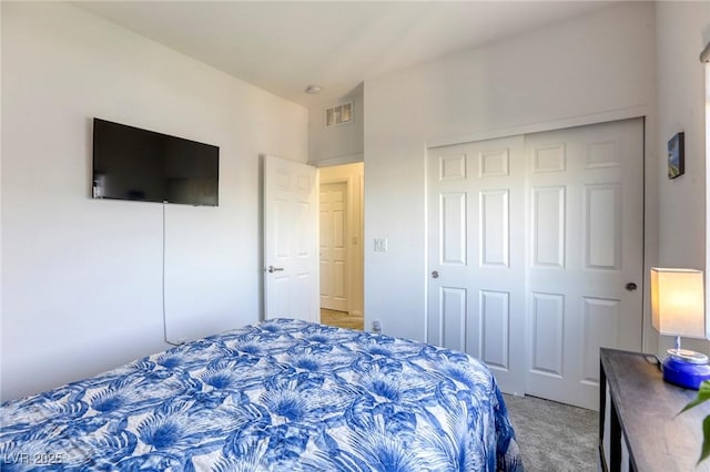 bedroom with light colored carpet, visible vents, and a closet