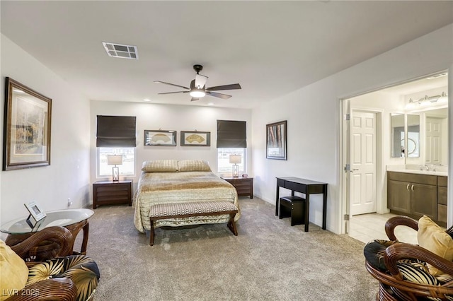 bedroom featuring visible vents, multiple windows, light colored carpet, and a sink