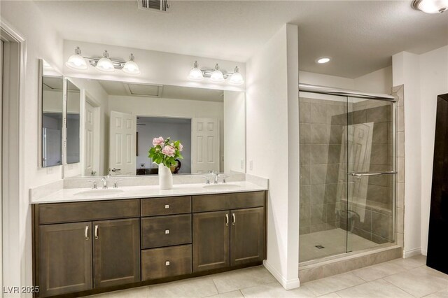 bathroom featuring tile patterned flooring, a sink, a shower stall, and double vanity