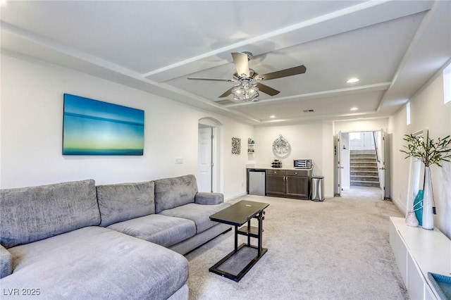 living room with recessed lighting, ceiling fan, stairs, arched walkways, and light colored carpet
