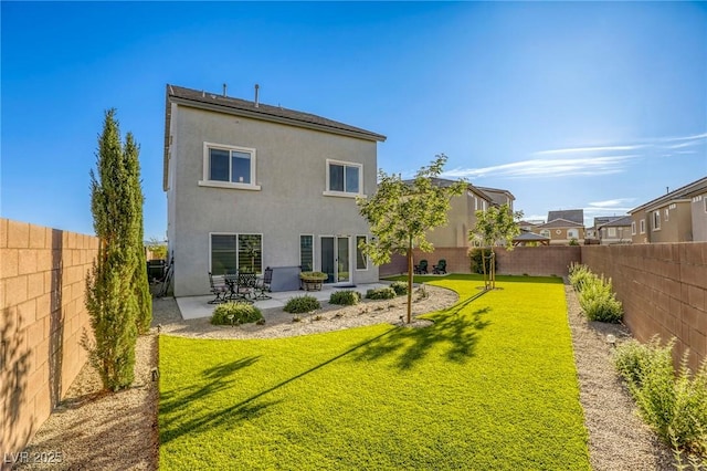 rear view of property with a fenced backyard, stucco siding, a yard, and a patio area