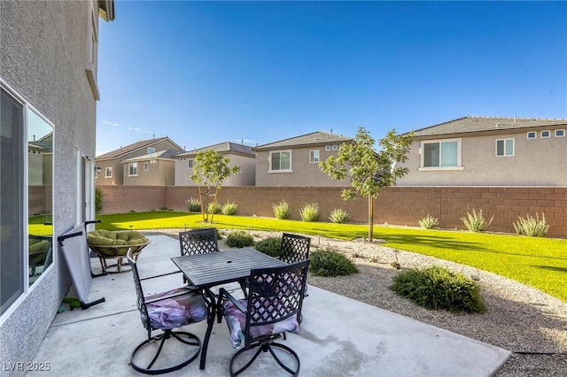 view of patio / terrace with fence, outdoor dining space, and a residential view