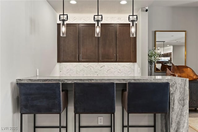 interior space featuring recessed lighting, decorative light fixtures, and indoor bar