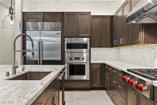 kitchen featuring a sink, range hood, decorative backsplash, and stainless steel appliances
