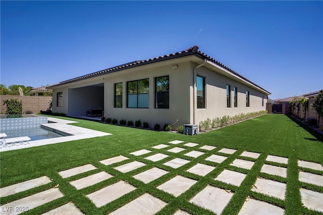 back of house with a fenced backyard, a patio, a lawn, and stucco siding