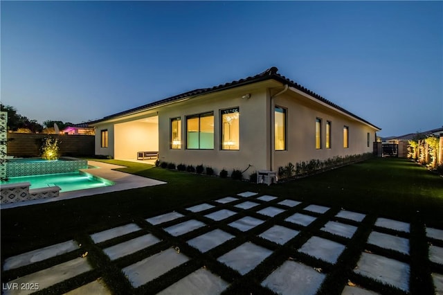 back of house with a yard, a fenced backyard, a patio, and stucco siding