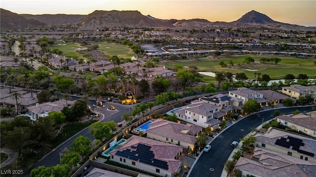 aerial view at dusk with a mountain view, a residential view, and view of golf course