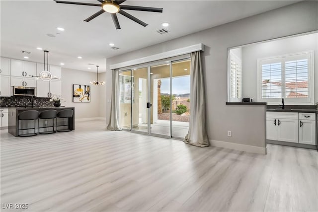 1185 Via Casa Palermo, Henderson, NV 89011 - living area featuring visible vents, light wood finished floors, baseboards, and ceiling fan with notable chandelier