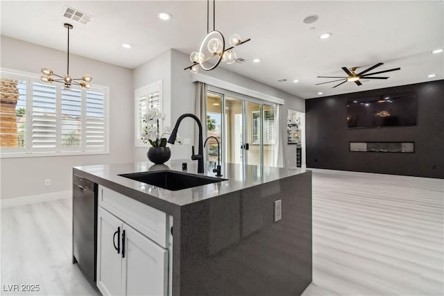 1185 Via Casa Palermo, Henderson, NV 89011 - kitchen with stainless steel dishwasher, a sink, light wood-type flooring, baseboards, and visible vents