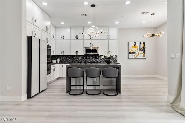 1185 Via Casa Palermo, Henderson, NV 89011 - kitchen with freestanding refrigerator, dark countertops, visible vents, and an inviting chandelier