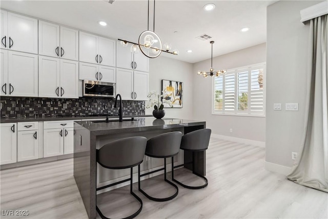 1185 Via Casa Palermo, Henderson, NV 89011 - kitchen featuring stainless steel microwave, dark countertops, a sink, and visible vents