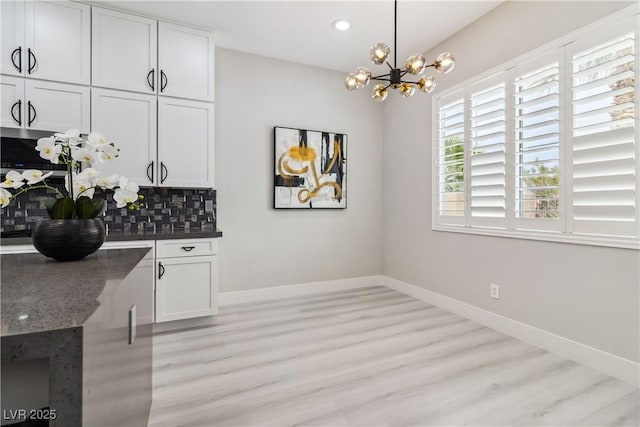 1185 Via Casa Palermo, Henderson, NV 89011 - kitchen featuring decorative backsplash, an inviting chandelier, light wood finished floors, baseboards, and white cabinetry