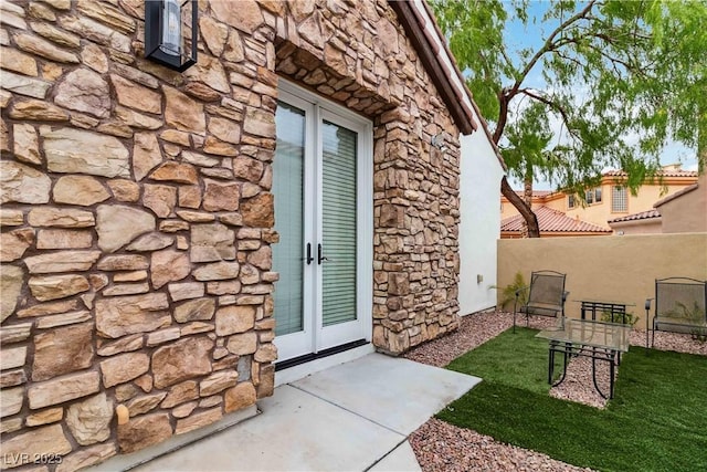 1185 Via Casa Palermo, Henderson, NV 89011 - view of exterior entry with stucco siding, french doors, stone siding, and fence