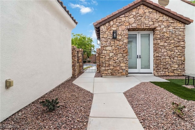1185 Via Casa Palermo, Henderson, NV 89011 - view of home's exterior with stone siding, french doors, a gate, and stucco siding
