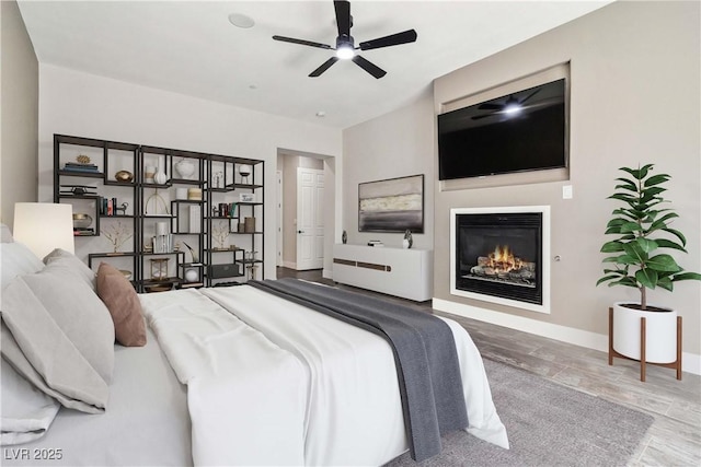 1185 Via Casa Palermo, Henderson, NV 89011 - bedroom with baseboards, wood finished floors, a glass covered fireplace, and ceiling fan