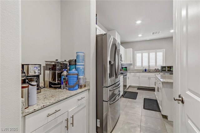 8351 Gold River Ct, Las Vegas, NV 89113 - kitchen featuring stainless steel appliances, a sink, visible vents, white cabinetry, and light tile patterned floors