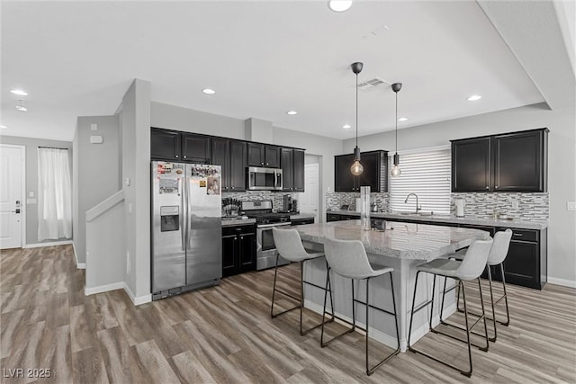 5419 Holding Ave, Las Vegas, NV 89139 - kitchen featuring dark cabinets, visible vents, a kitchen bar, and stainless steel appliances