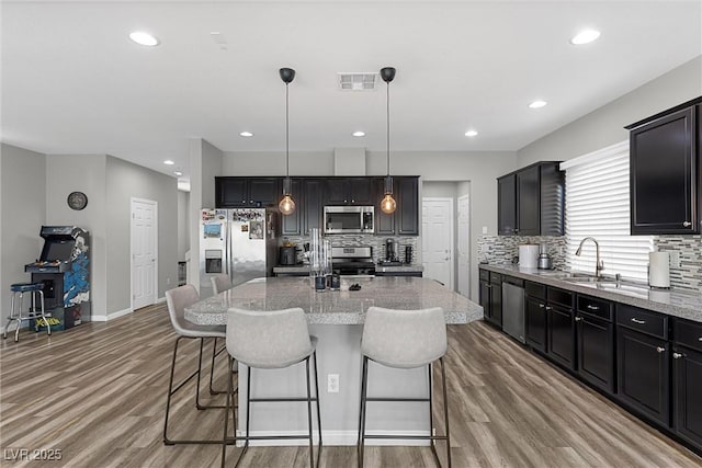 5419 Holding Ave, Las Vegas, NV 89139 - kitchen featuring light wood-style floors, tasteful backsplash, visible vents, a sink, and stainless steel appliances