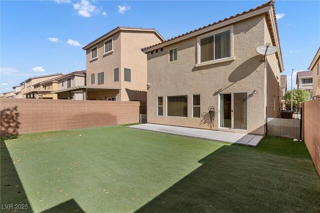 5419 Holding Ave, Las Vegas, NV 89139 - back of house featuring a tiled roof, a fenced backyard, a lawn, and stucco siding