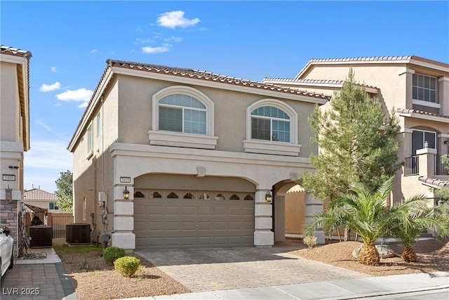 5419 Holding Ave, Las Vegas, NV 89139 - mediterranean / spanish-style home featuring a garage, central AC unit, stucco siding, and decorative driveway