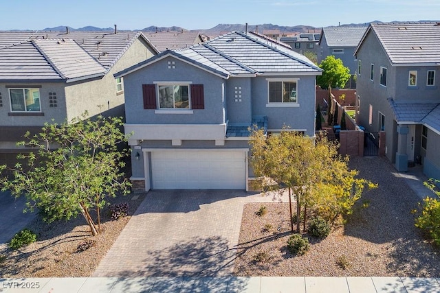 traditional home featuring a tile roof, a garage, decorative driveway, and stucco siding