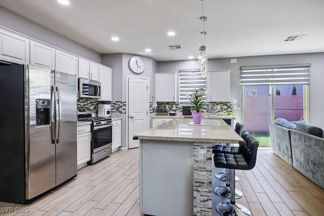 kitchen featuring stainless steel appliances, visible vents, light wood-type flooring, and white cabinets