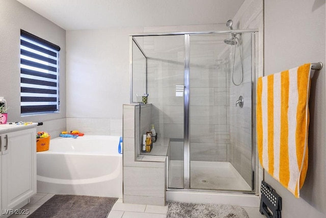 bathroom with vanity, a shower stall, tile patterned flooring, and a garden tub