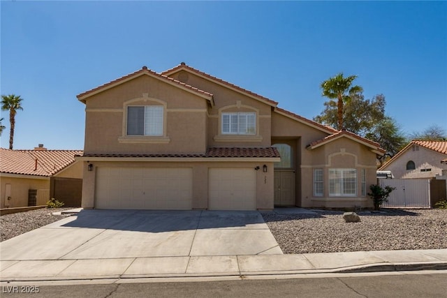 mediterranean / spanish-style house with a tiled roof, stucco siding, fence, a garage, and driveway
