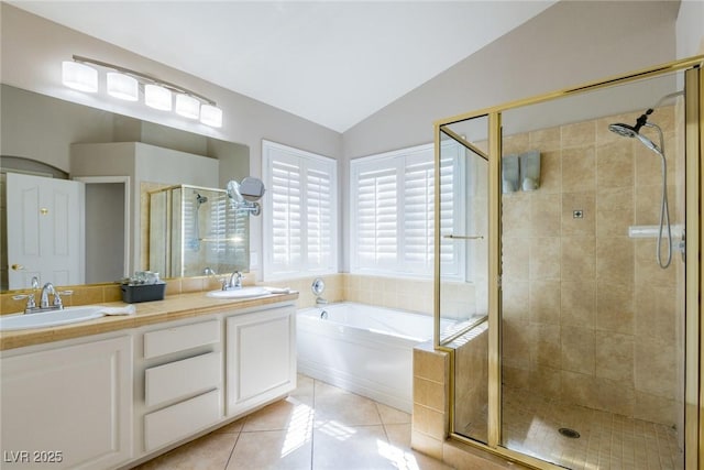 bathroom with a sink, vaulted ceiling, tile patterned floors, a stall shower, and a garden tub
