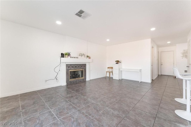 unfurnished living room with tile patterned floors, a fireplace, visible vents, and recessed lighting