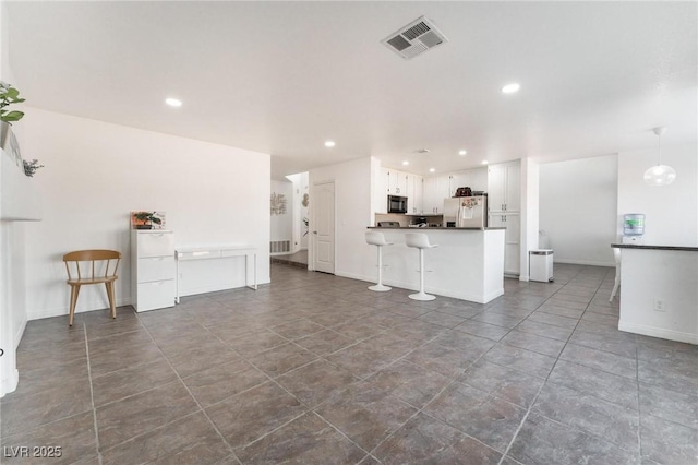 unfurnished living room featuring recessed lighting, visible vents, and baseboards