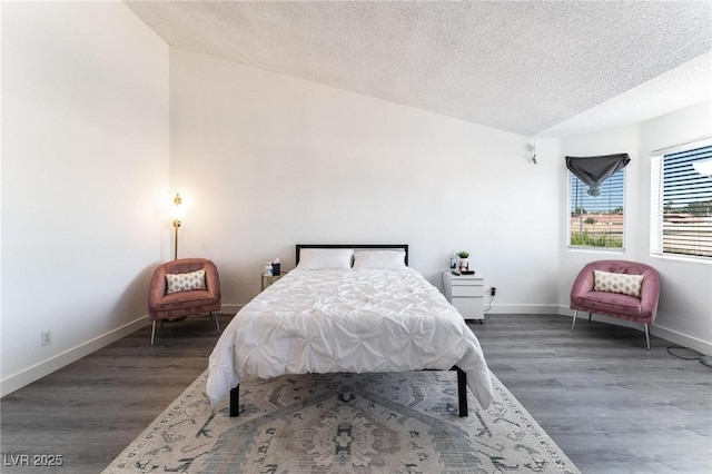bedroom with a textured ceiling, wood finished floors, and baseboards