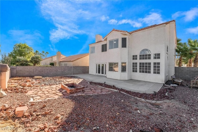 back of property featuring a patio area, a fenced backyard, a fire pit, and stucco siding