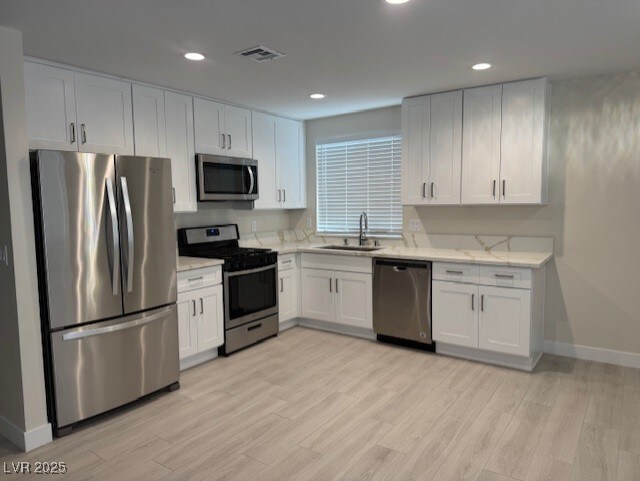 432 Anchor St, Las Vegas, NV 89110 - kitchen featuring visible vents, baseboards, a sink, light wood finished floors, and stainless steel appliances