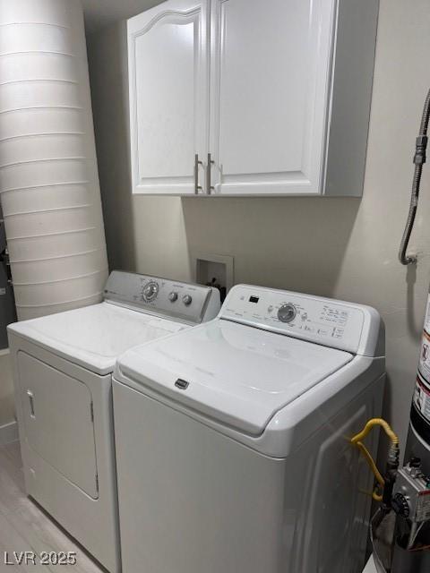 432 Anchor St, Las Vegas, NV 89110 - washroom with light wood-style floors, separate washer and dryer, and cabinet space