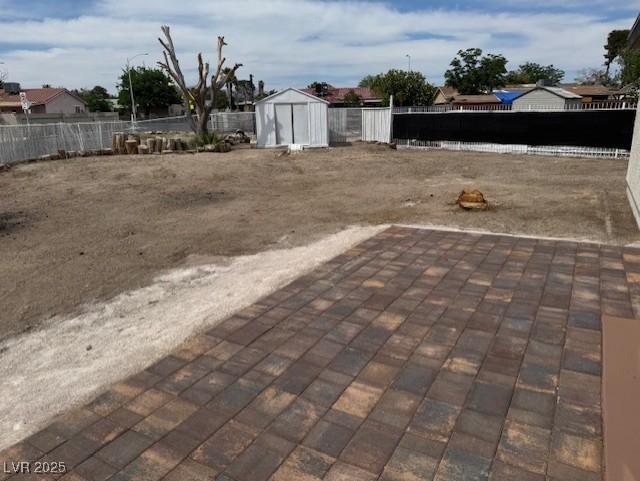 432 Anchor St, Las Vegas, NV 89110 - view of yard featuring an outbuilding, a storage unit, a fenced backyard, and a patio area