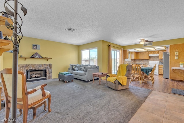 468 Potomac St, Henderson, NV 89015 - living area with a premium fireplace, ceiling fan, a textured ceiling, and light tile patterned floors