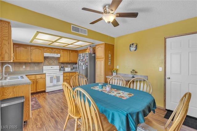 468 Potomac St, Henderson, NV 89015 - dining room with light wood-style floors, a ceiling fan, and a textured ceiling