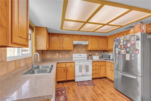 468 Potomac St, Henderson, NV 89015 - kitchen with stainless steel appliances, a sink, under cabinet range hood, light countertops, and light wood-style floors