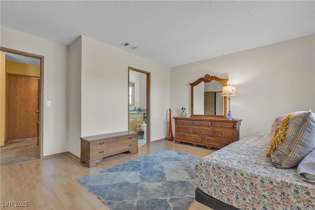 468 Potomac St, Henderson, NV 89015 - bedroom featuring light wood-style flooring, a textured ceiling, and ensuite bathroom