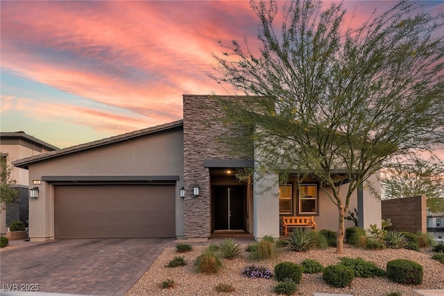 109 Reverie Heights Ave, Henderson, NV 89011 - view of front of house featuring stucco siding, a garage, driveway, and stone siding
