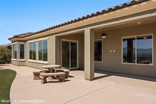 back of property featuring a patio, stucco siding, and a tile roof
