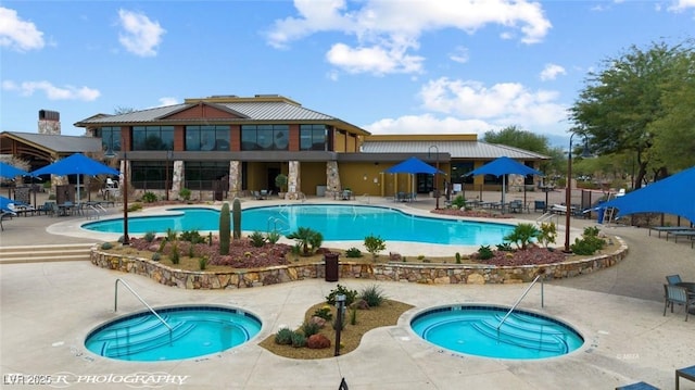 community pool with a patio, a community hot tub, and fence